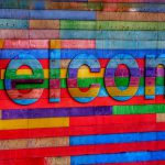 multiple pieces of colored wood on a wall spell out welcome