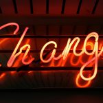 red neon sign that reads change