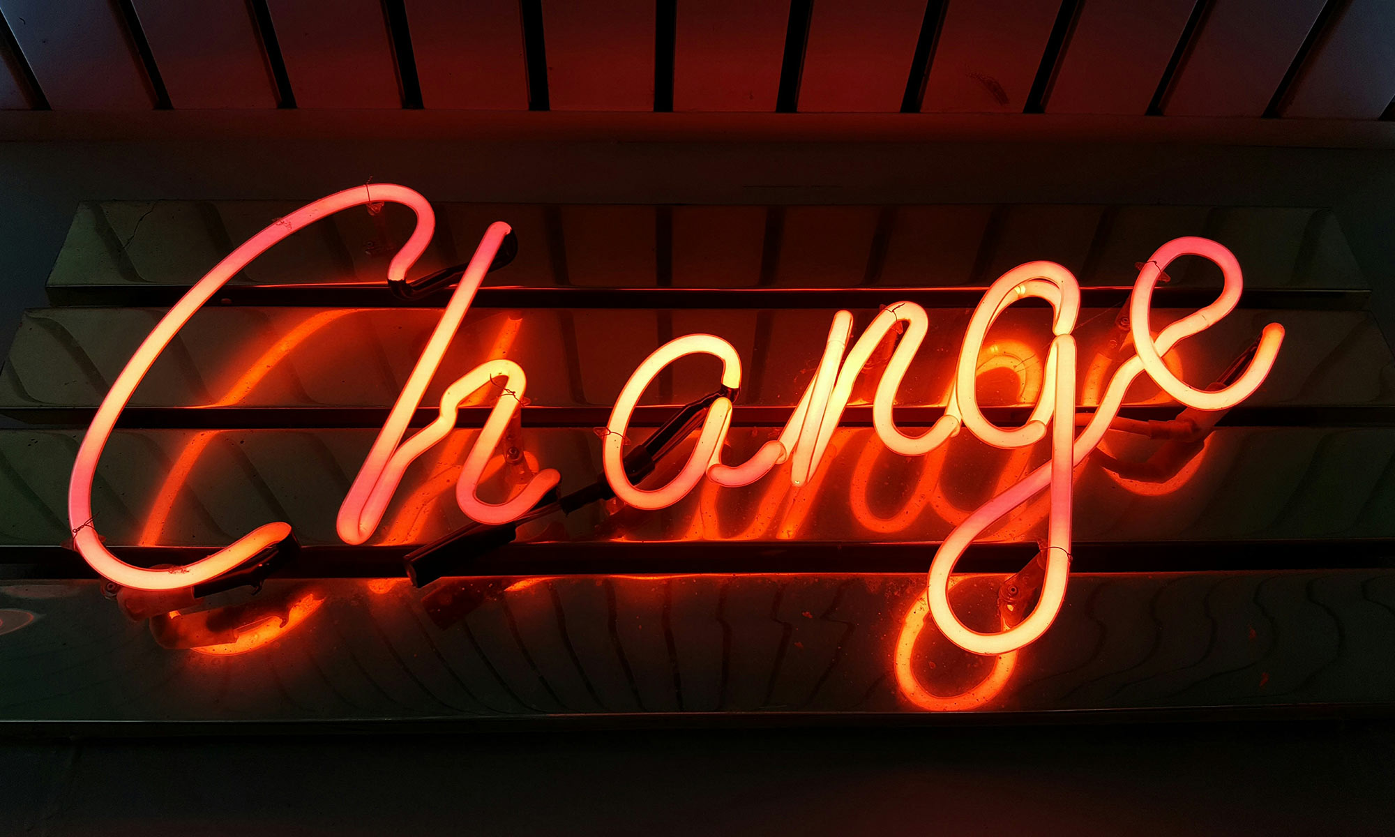 red neon sign that reads change