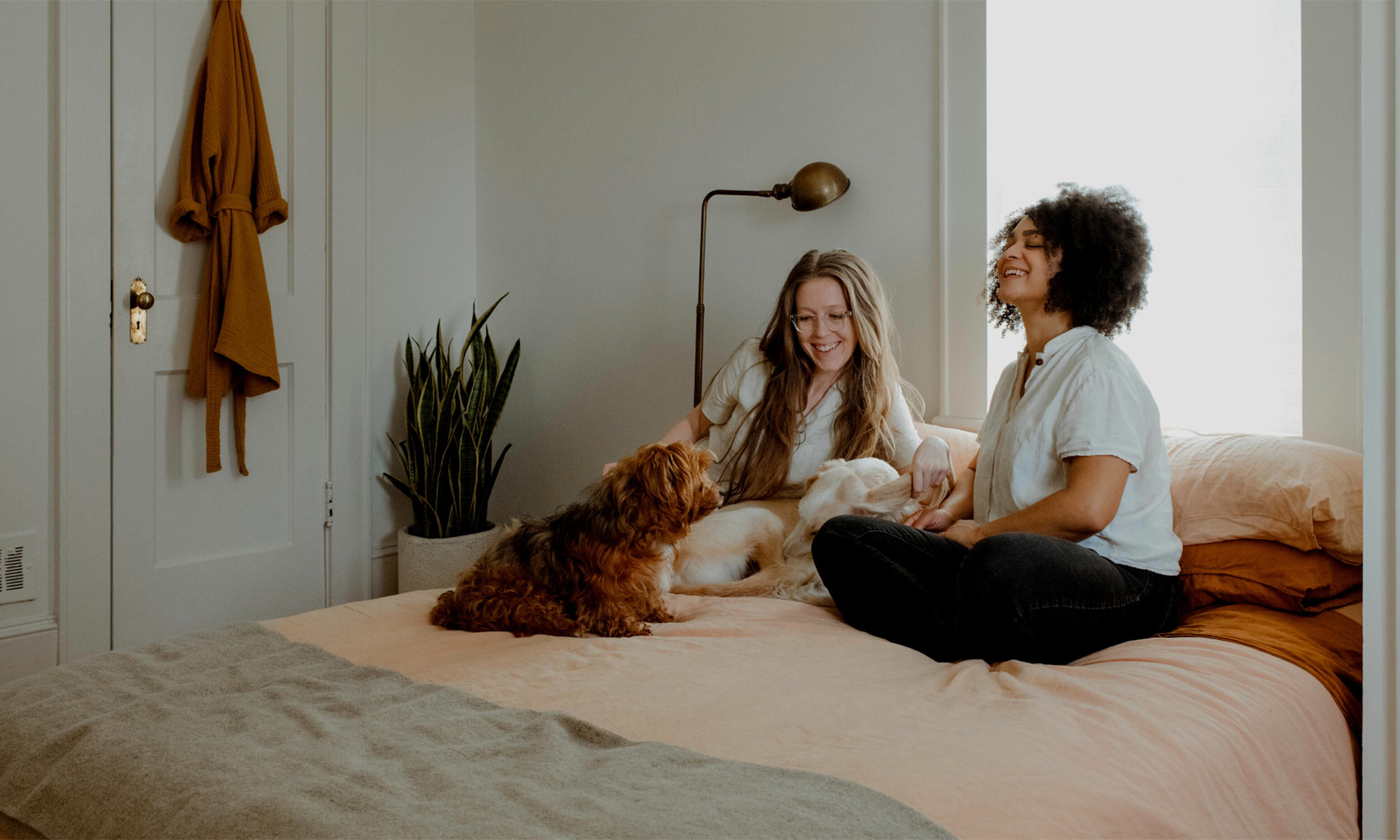 couple sitting in their bed with their pets