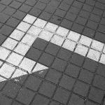 white arrow on a grey sidewalk