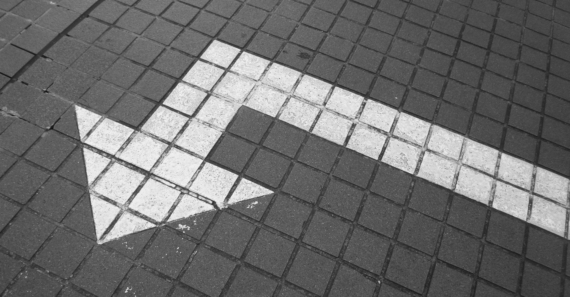 white arrow on a grey sidewalk