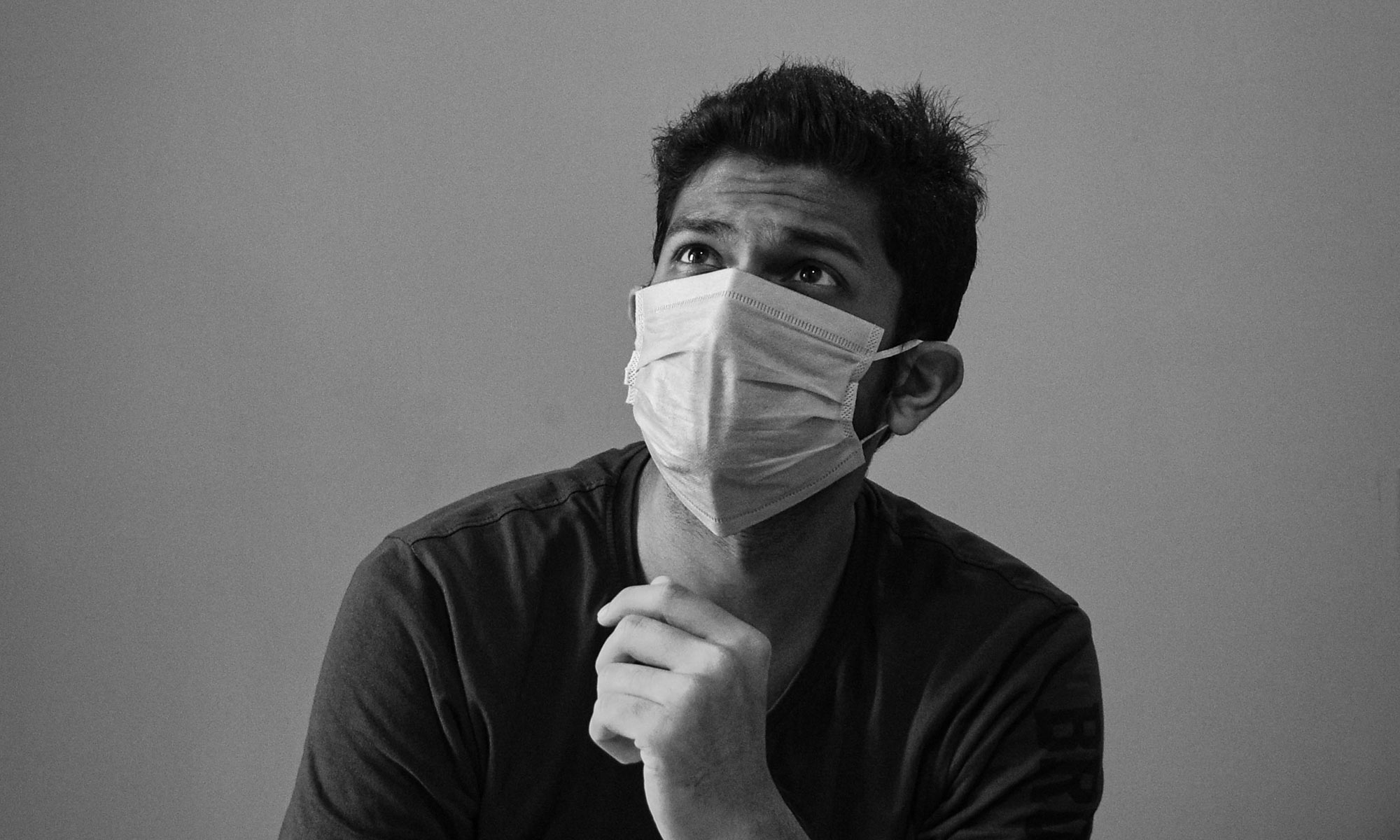 person wearing a protective face-mask looking into the distance