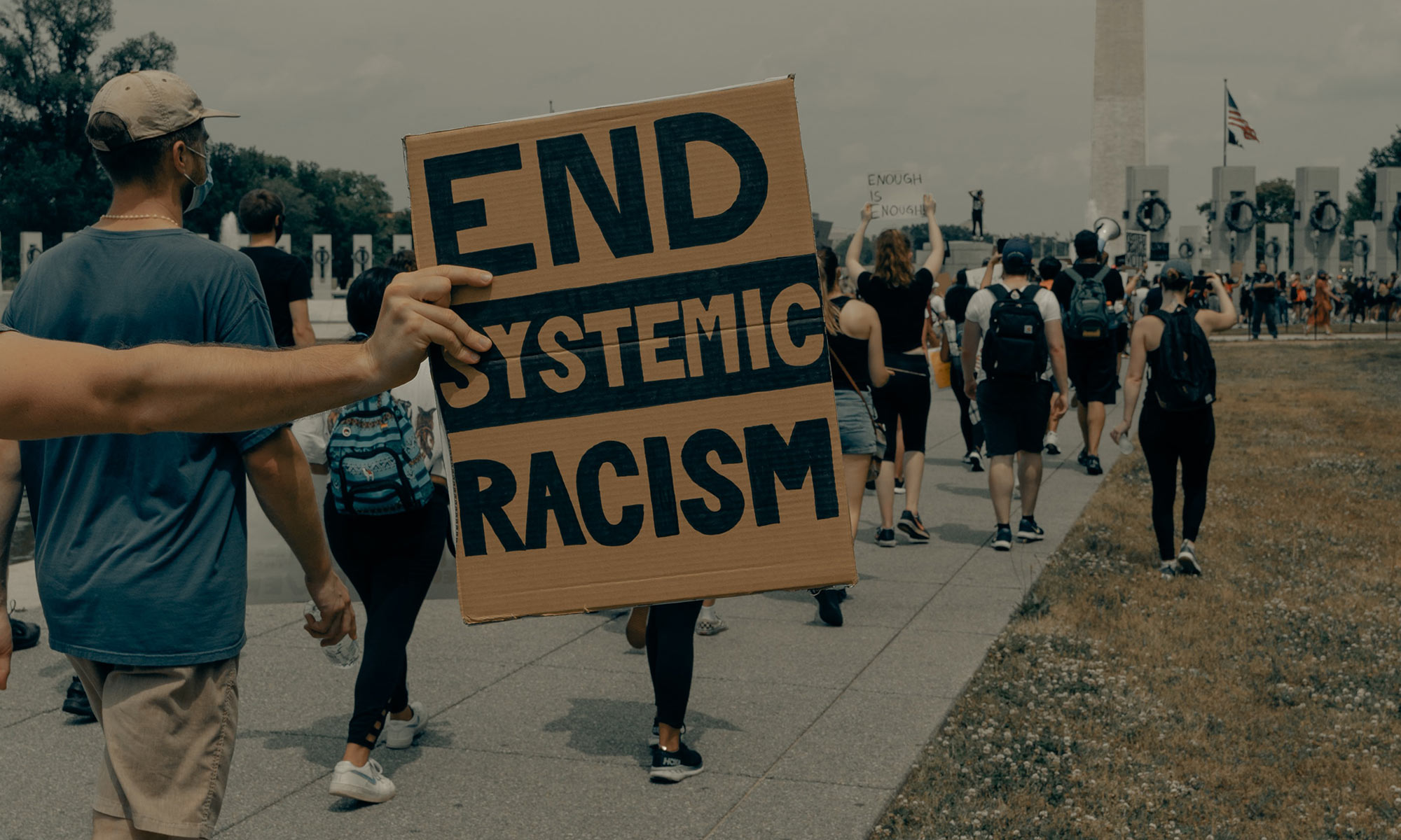 person holding an 'end systemic racism' sign at a protest in washington dc